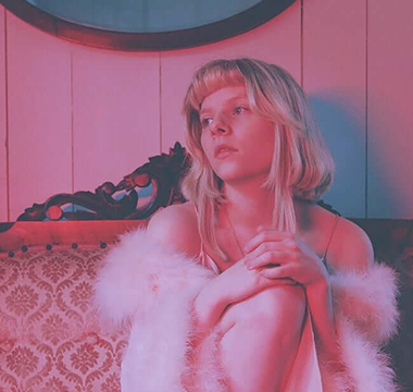 picture of aurora sitting down pink tones