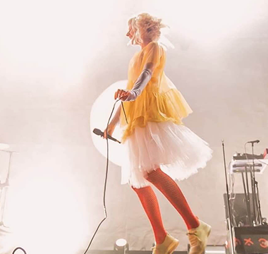 picture of aurora in a yellow dress during a concert